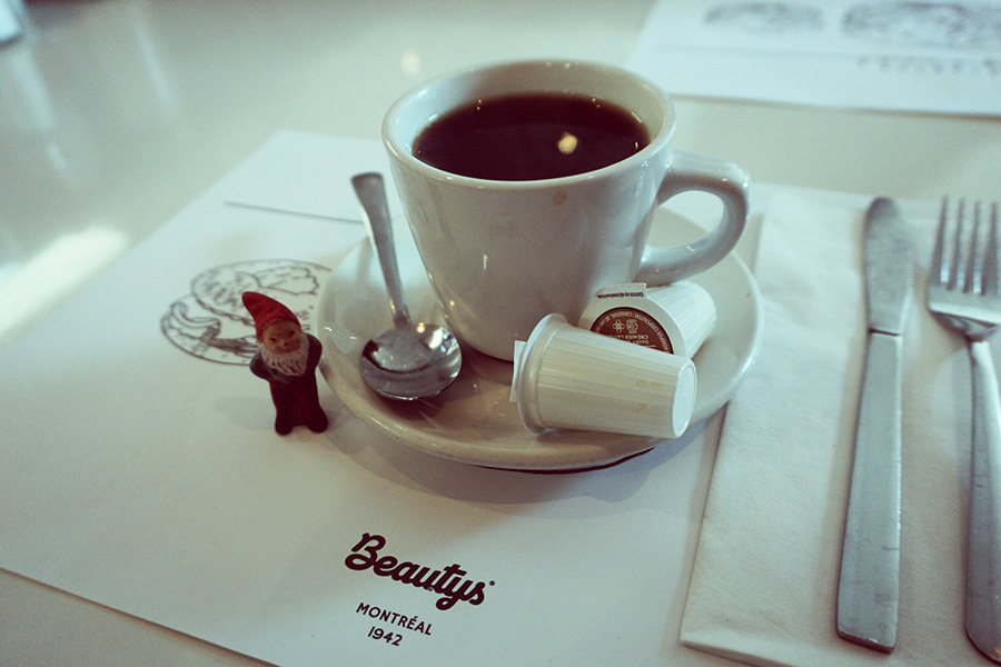 photo of diner coffee and a small garden gnome. Montreal, Quebec, Canada