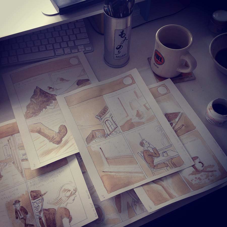 photo of coffee cup and my pencilled comic book pages all coloured with coffee.