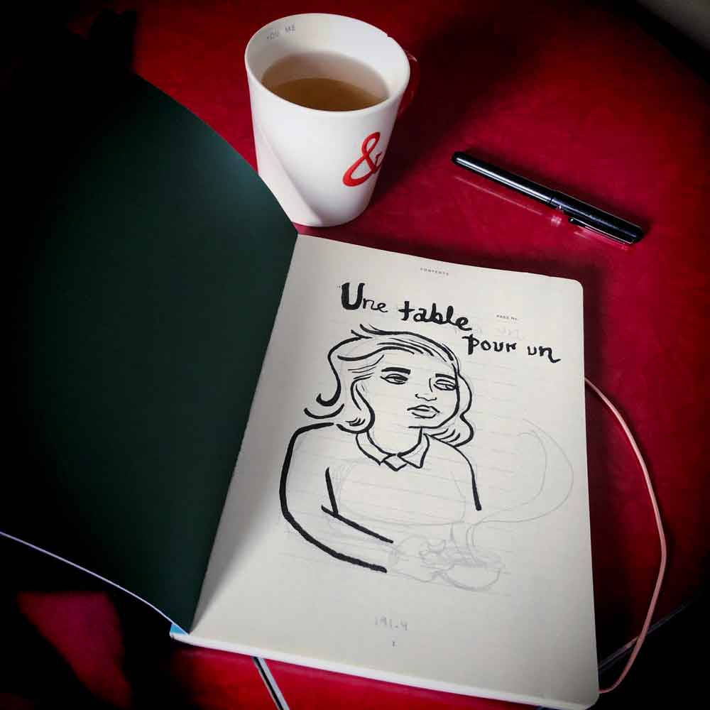 photo of a new sketchbook, a pen, and a cup of coffee.